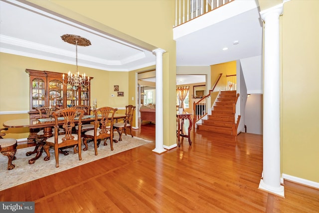 9743 Wyndham Dr, Frederick, MD 21704 - dining space featuring ornate columns, light wood-type flooring, crown molding, stairs, and baseboards