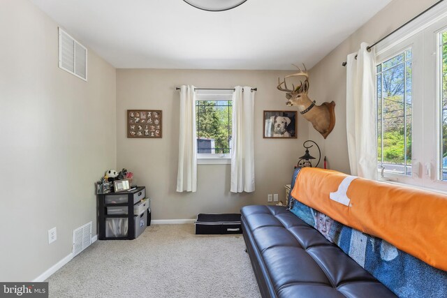 living room with visible vents, carpet floors, and a healthy amount of sunlight