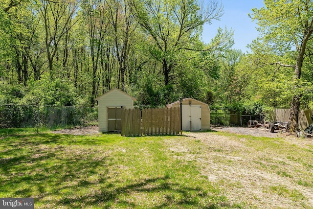 view of yard with a storage unit, a fenced backyard, and an outbuilding