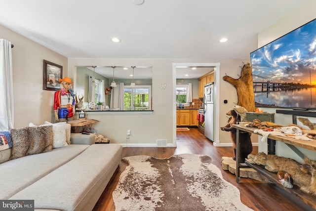 living area featuring visible vents, recessed lighting, baseboards, and dark wood-type flooring