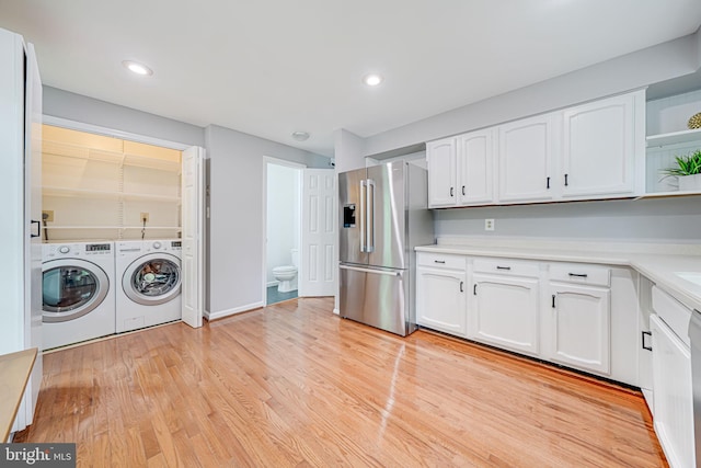 2 S Manchester St S, Arlington, VA 22204 - kitchen featuring high end refrigerator, separate washer and dryer, white cabinets, light countertops, and light wood finished floors