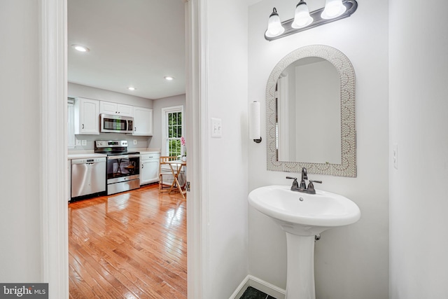 2 S Manchester St S, Arlington, VA 22204 - bathroom featuring hardwood / wood-style flooring, recessed lighting, baseboards, and a sink