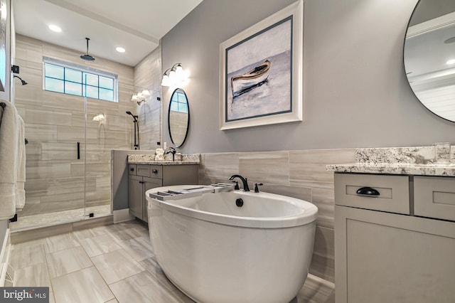 404 Wiggins Mill Rd, Townsend, DE 19734 - bathroom with a freestanding tub, tile walls, wainscoting, a stall shower, and vanity