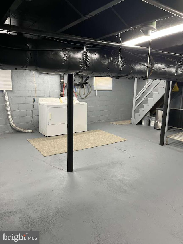 unfinished below grade area with stairs and washing machine and clothes dryer