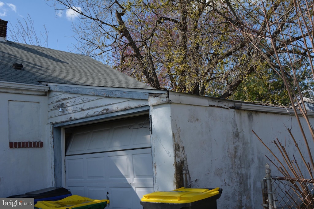 exterior details featuring fence and roof with shingles