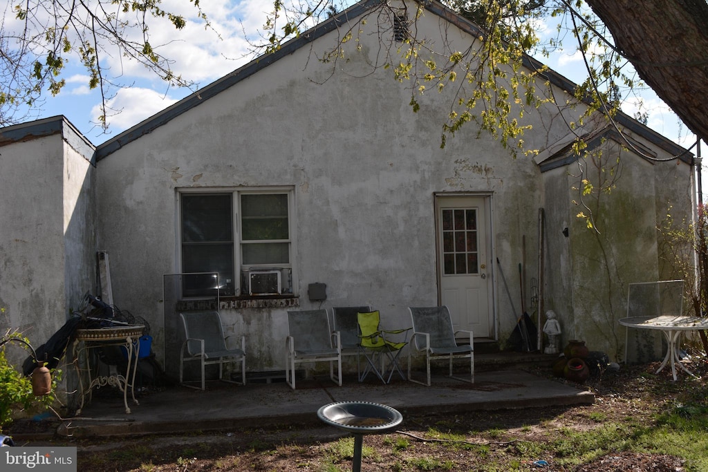 rear view of house featuring stucco siding and a patio area
