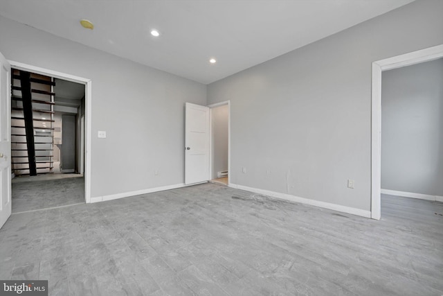 unfurnished bedroom with baseboards, a baseboard radiator, recessed lighting, and wood finished floors