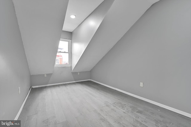 bonus room featuring baseboards, wood finished floors, and vaulted ceiling