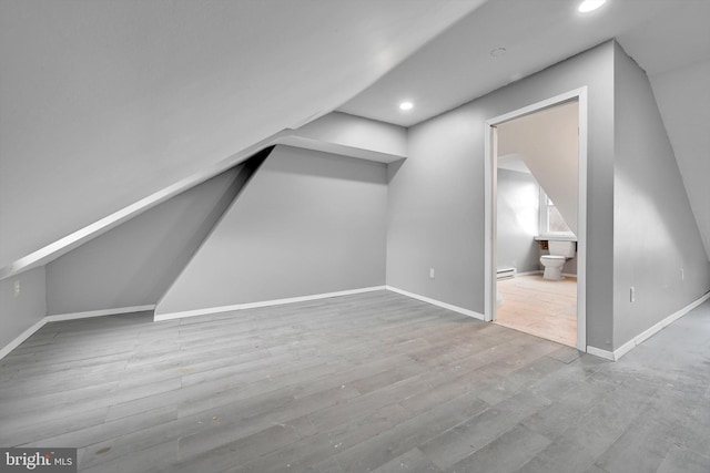 additional living space featuring baseboards, a baseboard radiator, recessed lighting, and wood finished floors