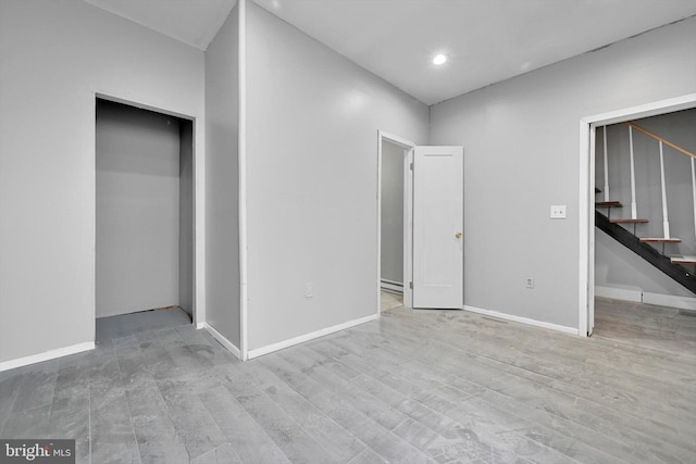 interior space with baseboards, wood finished floors, and stairway