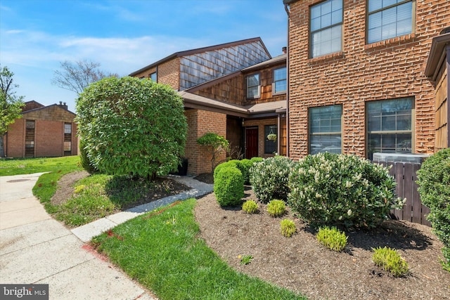 property entrance featuring central air condition unit and brick siding