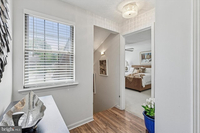 corridor with baseboards and wood finished floors
