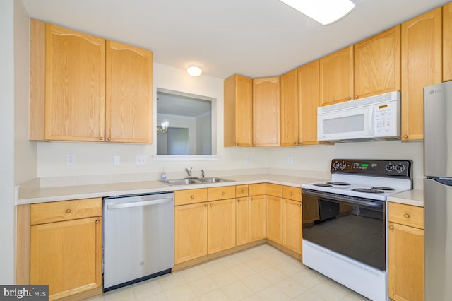kitchen with light brown cabinetry, a sink, light countertops, stainless steel appliances, and light floors