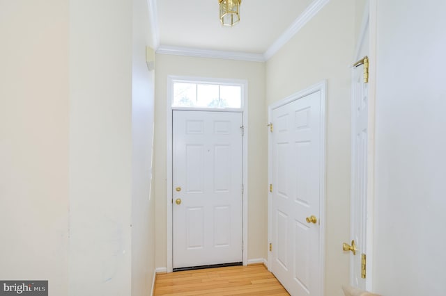 entryway with crown molding, light wood finished floors, and baseboards