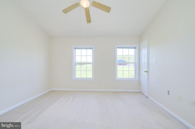 carpeted empty room featuring baseboards, a ceiling fan, and lofted ceiling