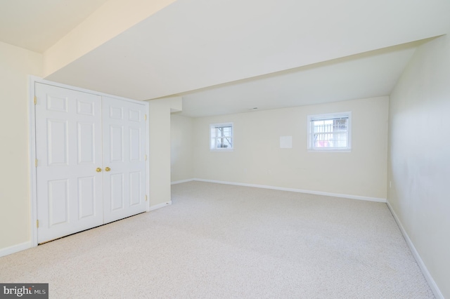 below grade area featuring carpet flooring and baseboards