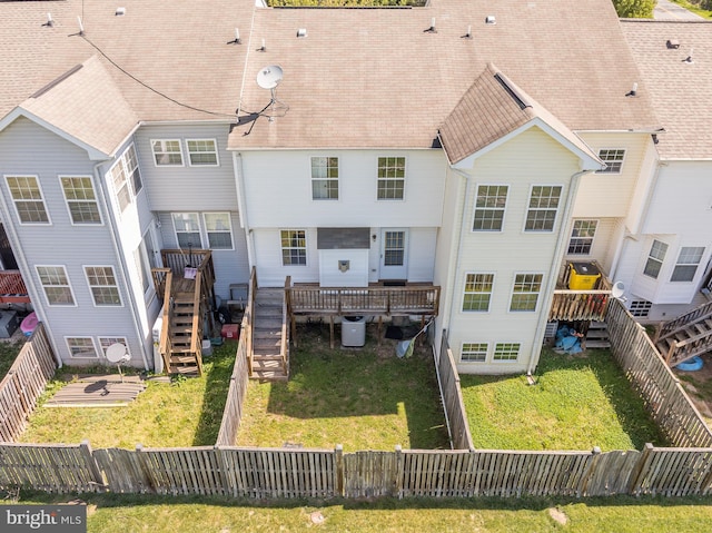 back of house with stairway, a deck, a yard, and a fenced backyard