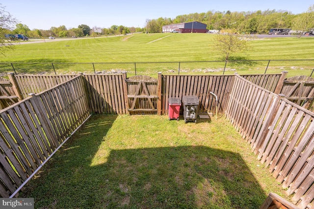 view of yard featuring a fenced backyard and a gate