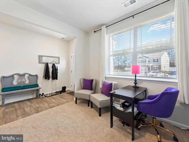 sitting room featuring visible vents, baseboards, and wood finished floors