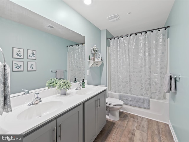 bathroom with a sink, shower / bathtub combination with curtain, toilet, and wood finished floors