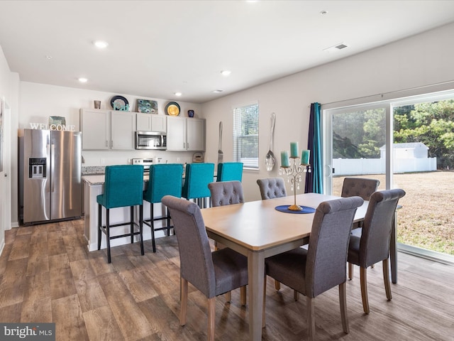 dining area featuring recessed lighting, plenty of natural light, and wood finished floors