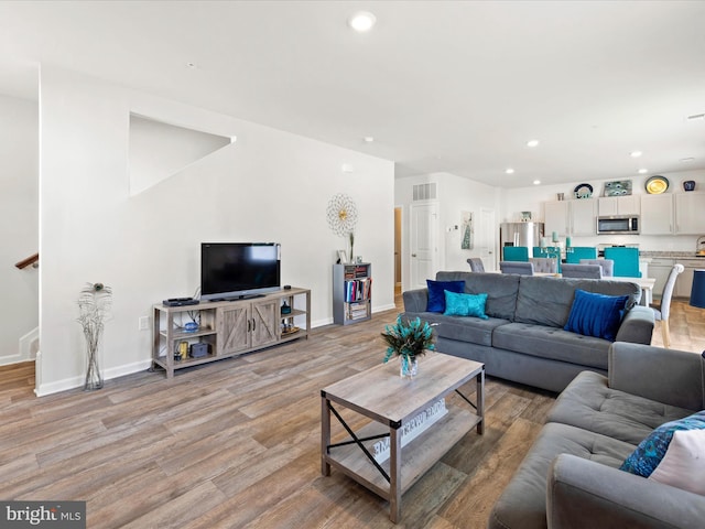 living area with visible vents, recessed lighting, baseboards, and light wood-type flooring