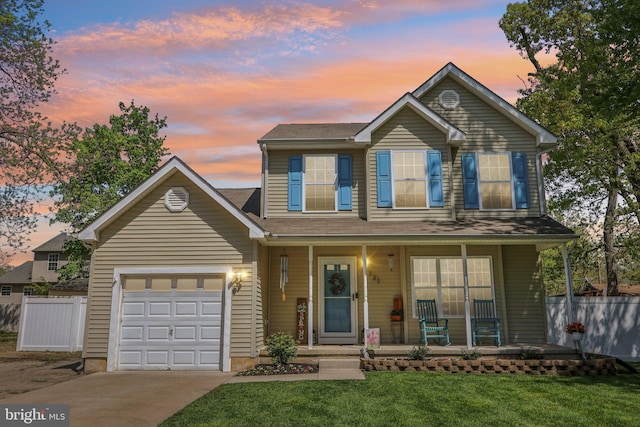 traditional-style house featuring a porch, fence, an attached garage, a yard, and concrete driveway