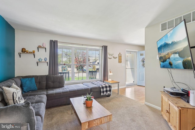 living room with light carpet, baseboards, and visible vents