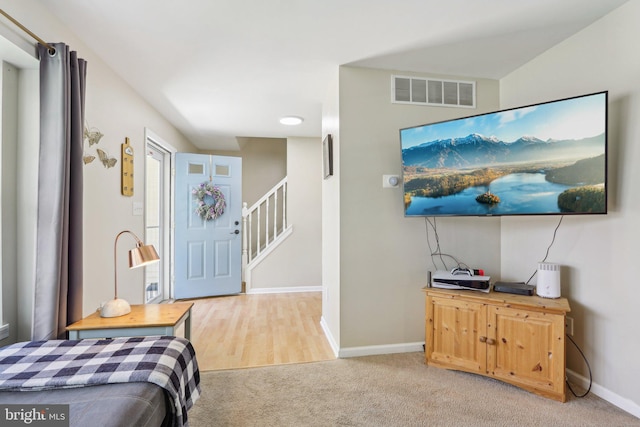 bedroom with light colored carpet, visible vents, and baseboards