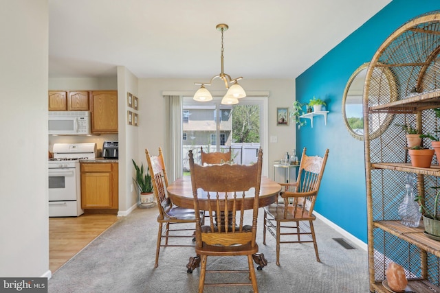 dining area featuring an inviting chandelier, light carpet, baseboards, and visible vents