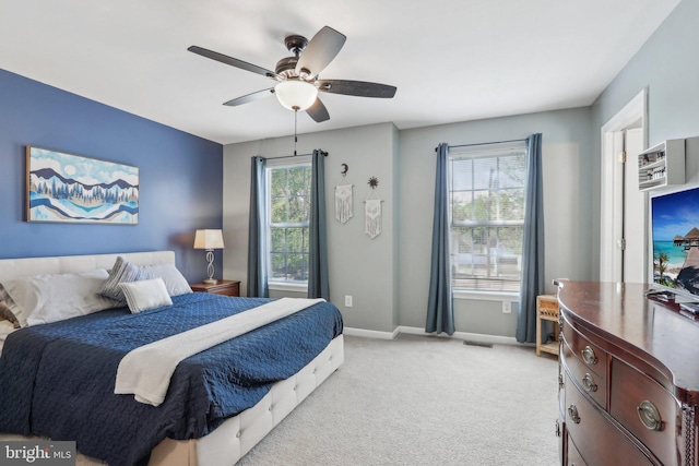 bedroom with ceiling fan, light carpet, and baseboards