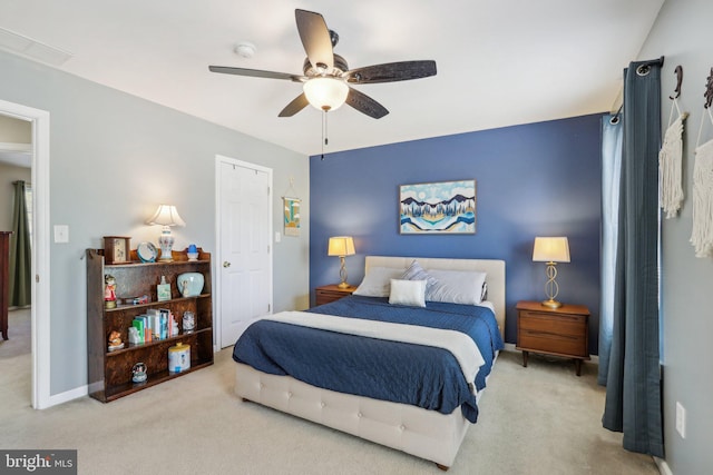 carpeted bedroom with visible vents, baseboards, and ceiling fan