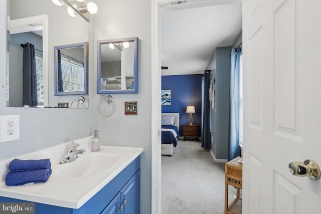 bathroom with vanity, ensuite bathroom, and baseboards