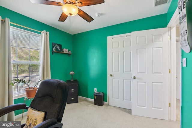 office space featuring carpet, visible vents, baseboards, and a ceiling fan
