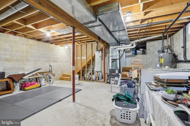unfinished basement with stairway, heating unit, concrete block wall, and gas water heater