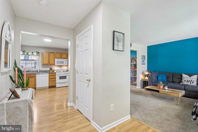 living area featuring baseboards and light wood-type flooring