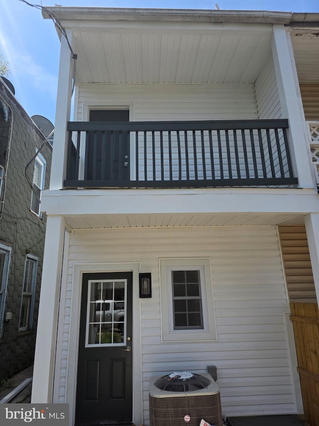 entrance to property with a balcony and cooling unit