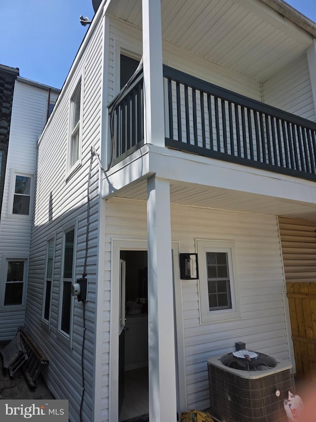 view of property exterior with central air condition unit and a balcony