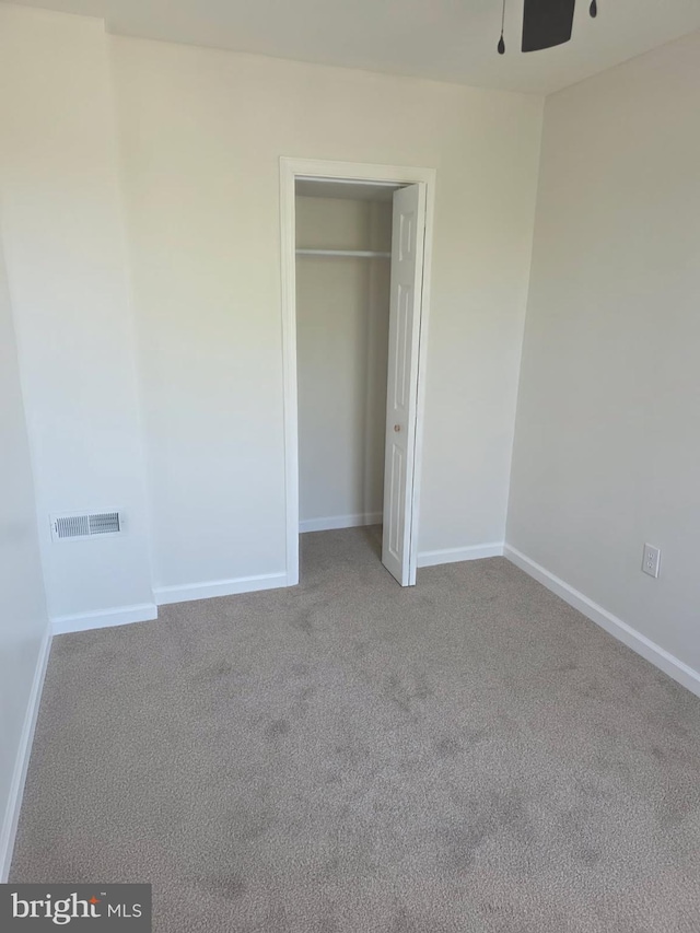 unfurnished bedroom featuring carpet floors, baseboards, visible vents, and a closet