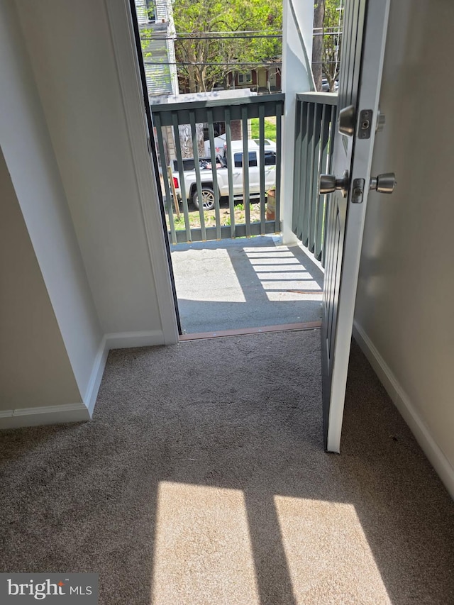 entryway with carpet floors, baseboards, and a healthy amount of sunlight