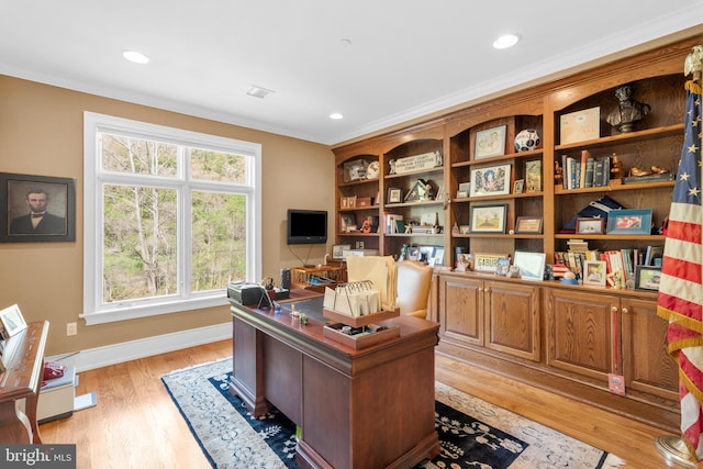 office space with baseboards, ornamental molding, and light wood finished floors