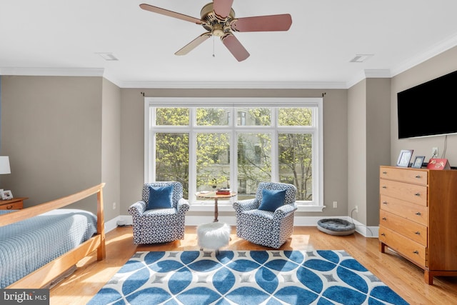 bedroom featuring light wood-style floors, ornamental molding, baseboards, and a ceiling fan