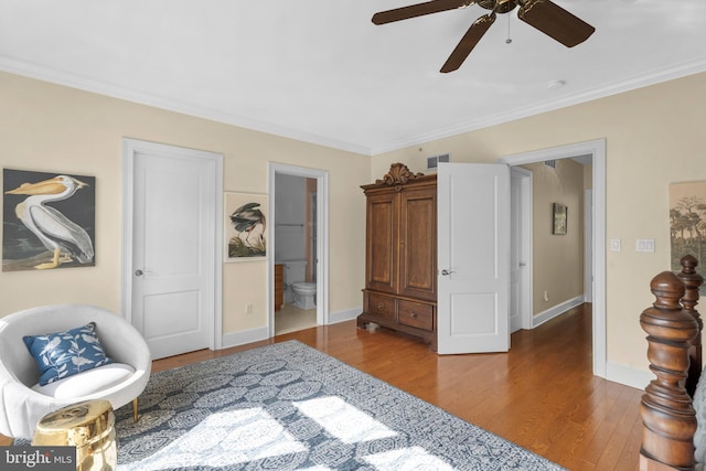 bedroom with crown molding, ensuite bath, baseboards, wood finished floors, and visible vents