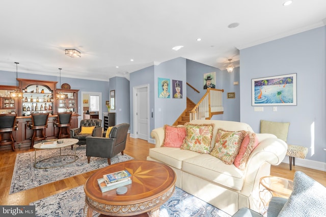 living room with crown molding, recessed lighting, stairway, and light wood finished floors