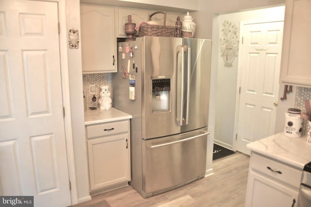 kitchen with light wood-style flooring, tasteful backsplash, and stainless steel fridge with ice dispenser