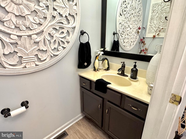 bathroom with vanity, baseboards, wood finished floors, and visible vents