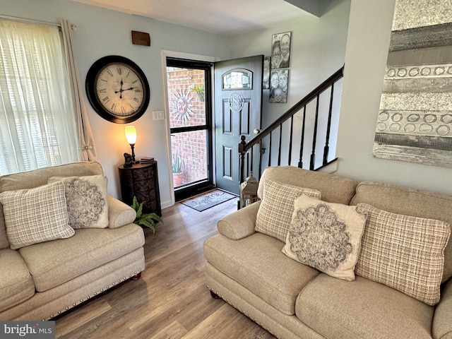 living room featuring wood finished floors and stairway