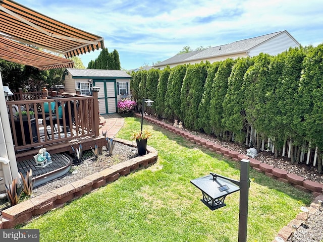 view of yard with an outdoor structure, a fenced backyard, and a wooden deck