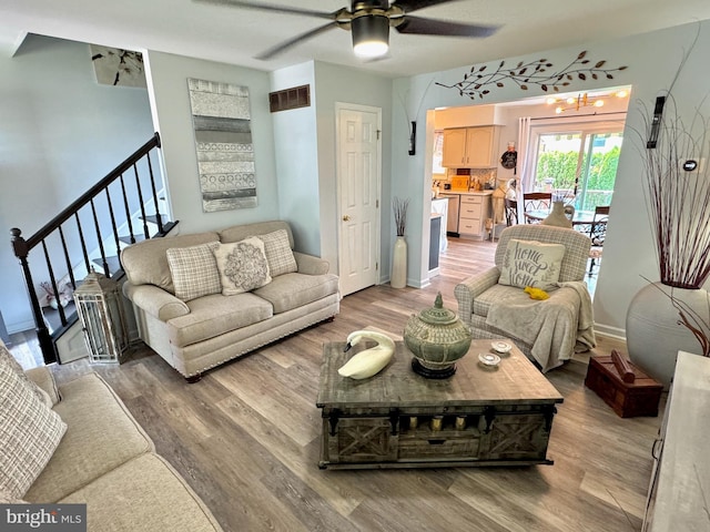 living area with light wood-style floors, baseboards, ceiling fan, and visible vents