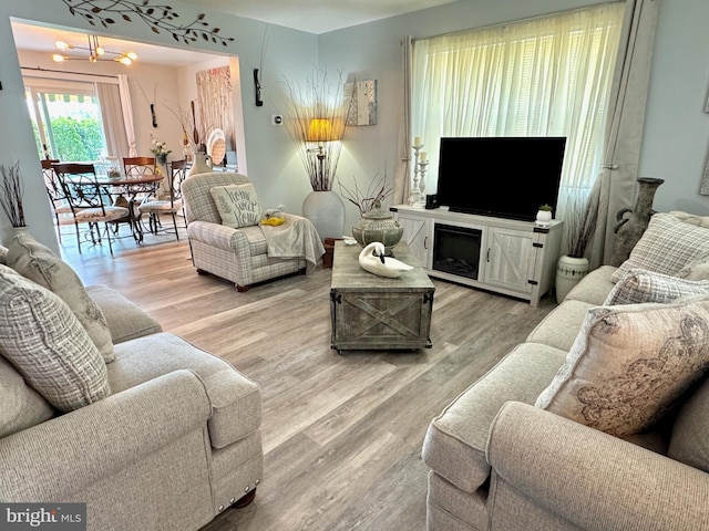 living area featuring an inviting chandelier and wood finished floors